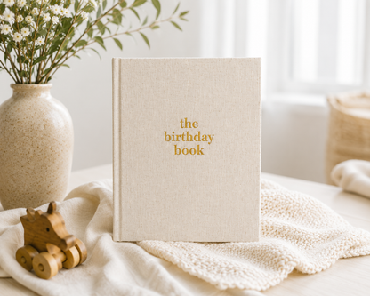 The Birthday Book heirloom keepsake journal with linen cover and gold foil lettering · The Birthday Book open to a birthday memory page with writing prompts · The Birthday Book interior pages showing letter and memory sections · The Birthday Book premium keepsake journal for recording 18 years of birthdays · The Birthday Book linen cover detail with gold accent lettering · The Birthday Book lay-flat binding for easy writing · The Birthday Book archival acid-free pages for lasting memories · The Birthday Boo
